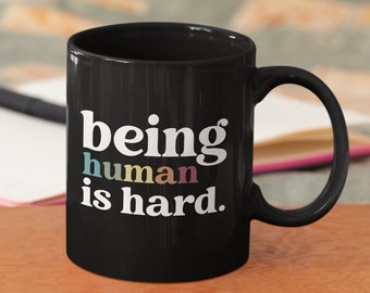 Être humain est une tasse dure - Tasse en céramique noire de 11 oz - Cadeaux empathiques - Tasses drôles - Cadeau de sympathie - Cadeau de deuil