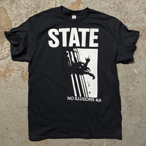 May include: Black t-shirt with a white graphic of a silhouette of a person falling from a building with the text "STATE" and "NO ILLUSIONS e.p."