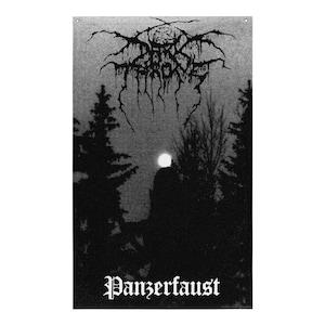 Peut inclure: Une bannière murale rectangulaire en tissu noir et blanc représentant la silhouette d'une forêt sombre sous une pleine lune. Le haut affiche le nom Darkthrone dans une police noire stylisée, et le bas porte le texte Panzerfaust en blanc.