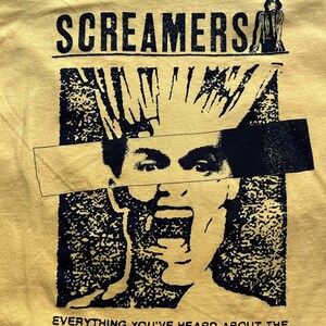 Puede incluir: Camiseta amarilla con un estampado gr&aacute;fico en blanco y negro de una persona gritando. El texto "Screamers" est&aacute; en la parte superior del gr&aacute;fico y el texto "Everything you've heard about the Screamers is true." est&aacute; en la parte inferior.