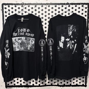 May include: A black long-sleeve t-shirt featuring white graphic prints. The front displays the text ZOUO the final agony above a black and white photo. The sleeves feature Japanese characters and circular logos. The back shows a group photo.