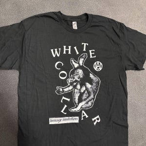 Könnte beinhalten: Schwarzes T-Shirt mit einem weißen Grafikdruck eines Kaninchens mit dem Text "WHITE COLLAR" und "teenage mutation" auf der Vorderseite.