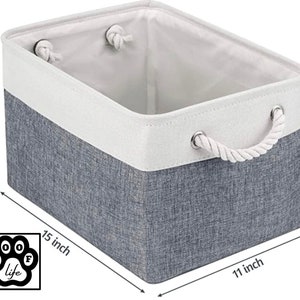 May include: A grey and white fabric storage bin with rope handles. The bin measures 15 inches wide, 11 inches long, and 9.5 inches high.