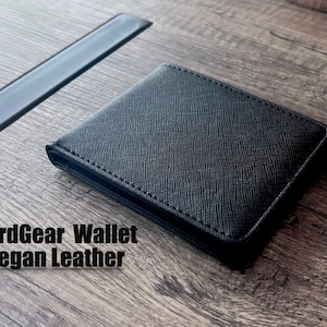 Billetera clásica delgada de cuero vegano, negra, con bloqueo RFID y ventana para identificación. Tiene capacidad para hasta 8 tarjetas. Sencilla y duradera. Regalo para él y para ella.