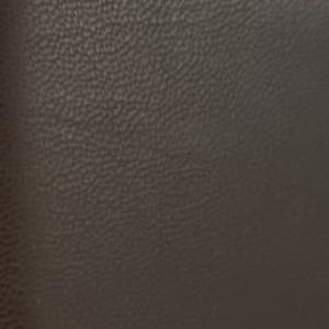 May include: Close-up of a dark brown leather texture. The leather has a fine, pebbled grain, and the lighting highlights subtle variations in color and texture. The overall appearance is smooth and uniform, suggesting a high-quality material.