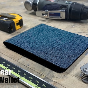 Cartera delgada de lona plegable, azul denim, con bloqueo RFID y ventana transparente para identificación. Capacidad para hasta 8 tarjetas. Sencilla y resistente. Regalo para él y para ella.