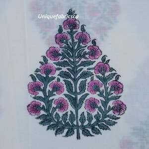 May include: A white fabric featuring a repeating floral motif in shades of pink and dark grey. The central design is a teardrop-shaped plant with pink blossoms and dark grey leaves. The text "Uniquefabricsco" is printed in small white letters.