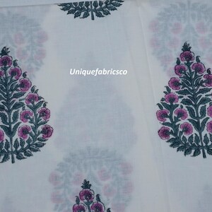 May include: A white fabric featuring a repeating pattern of dark green leafy trees with pink circular flowers. The text Uniquefabricsco is printed in the center of the fabric. The design is arranged in a grid-like layout across the material.