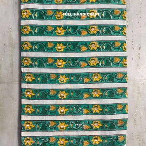 May include: A rectangular piece of fabric featuring horizontal stripes of white alternating with green bands. The green bands are decorated with a repeating pattern of yellow flowers and green leaves. The text FULLIHANDICRAFT is printed in white.
