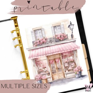 Könnte beinhalten: Druckbarer Planer-Aufkleber mit einer Aquarell-Illustration eines rosa und weißen Ladens mit einer rosa Markise. Der Laden hat einen Balkon mit rosa Blumen und ein Schild mit der Aufschrift "Boutique de Paris".
