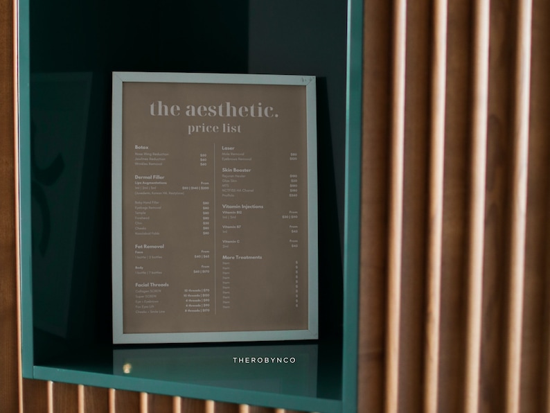 May include: A framed price list for aesthetic services, with the text "THE AESTHETIC. price list." The list includes services like Botox, dermal fillers, and laser treatments. The frame is white, set against a teal background, with a wooden slatted wall in the background.