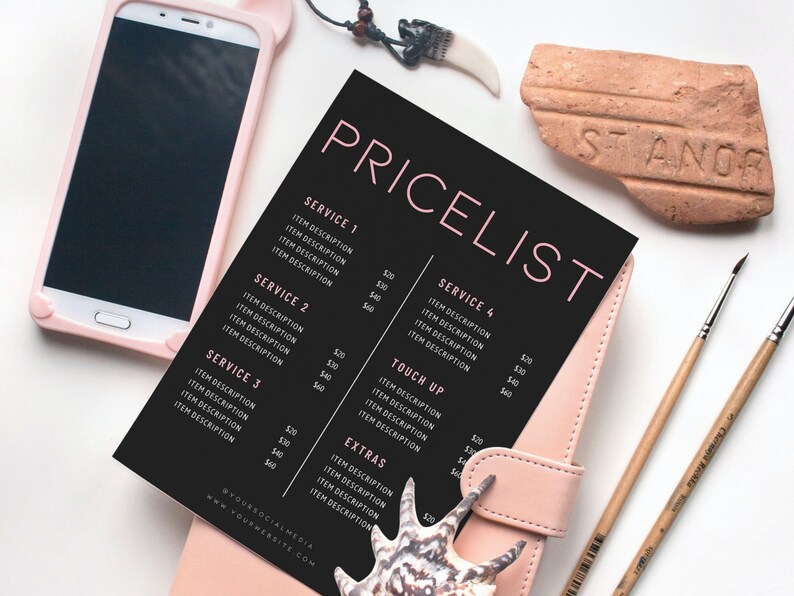 May include: A black and pink pricelist with item descriptions and prices, lying on a pink leather notebook. A smartphone in a pink case, paintbrushes, and decorative items are also present.
