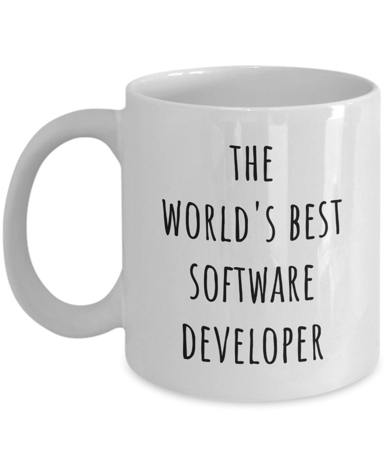 May include: White ceramic mug with a curved handle. The mug features black text that reads "THE WORLD'S BEST SOFTWARE DEVELOPER". The mug is a standard size and shape.