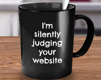 May include: Black coffee mug with white text that reads "I'm silently judging your website".