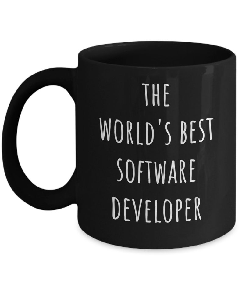 May include: Black ceramic mug with a white handle. The mug features the text "THE WORLD'S BEST SOFTWARE DEVELOPER" in white, centered on the front. The mug is designed for hot beverages.
