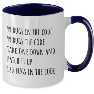 May include: White ceramic coffee mug with a blue rim and handle. The mug has black text that reads "99 bugs in the code, 99 bugs the code, take one down and patch it up, 120 bugs in the code".