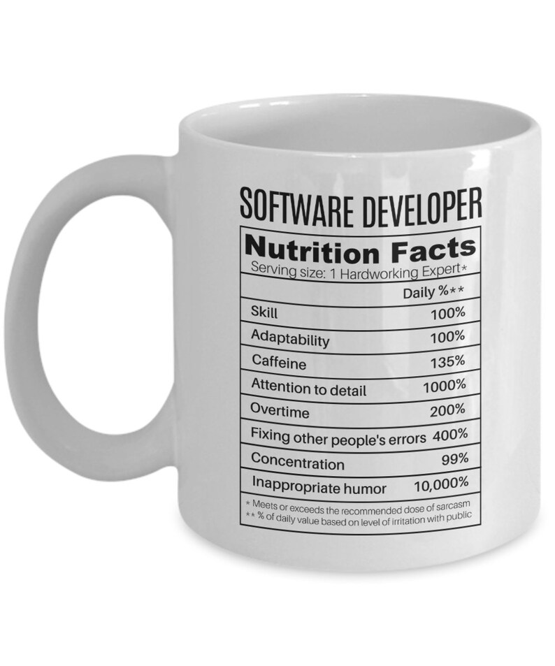Może przedstawiać: Biały ceramiczny kubek do kawy z czarno-białym nadrukiem etykiety wartości odżywczych dla programisty. Etykieta zawiera takie umiejętności jak: adaptacja, kofeina, dbałość o szczeg&oacute;ły, nadgodziny, naprawianie błęd&oacute;w innych, koncentracja i nieodpowiedni humor. Procenty są humorystyczne i przesadzone.