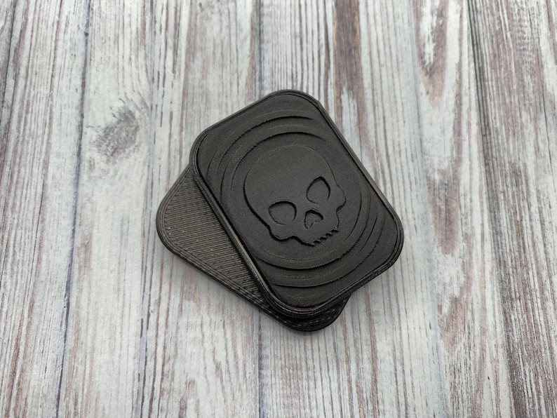 May include: Two black plastic skull-shaped keychains with a textured surface.