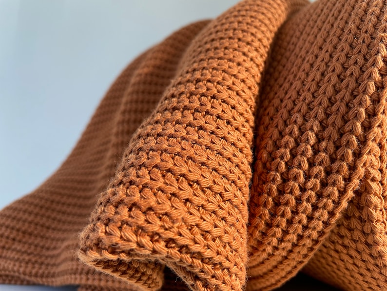 May include: A brown knitted throw blanket with a waffle stitch pattern.