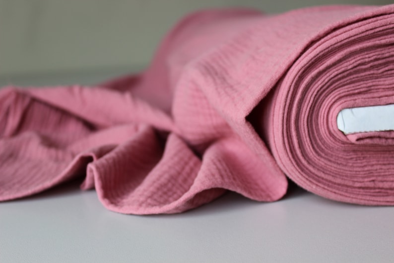 May include: A roll of pink waffle fabric. The fabric is soft and textured, and it is ideal for making clothes, blankets, or other crafts.