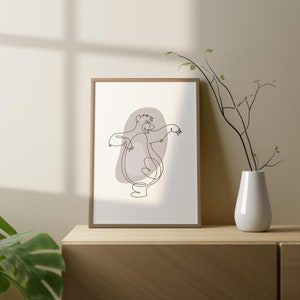 May include: A framed print of a line drawing of a bear dancing. The bear is brown and the background is a light brown color. The frame is a light wood color.