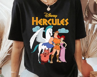 May include: Black t-shirt featuring the Disney movie "Hercules" logo in yellow and blue. The graphic includes Hercules, Megara, Pegasus, and Pain and Panic. The shirt is a crew neck and has short sleeves.