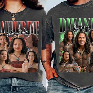 May include: Two dark gray t-shirts. One features the name "Catherine Laga'aia" in a red and white font, with multiple images of a woman. The other shirt displays "Dwayne Johnson" in a green and white font, with multiple images of the actor.