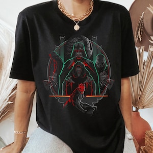 May include: Black t-shirt featuring a graphic of several characters from a science fiction movie franchise. The design includes Darth Vader, the Emperor, and Darth Maul, with red and green accents.
