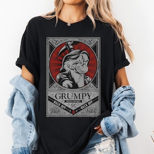 Op de afbeelding: Zwart T-shirt met een afbeelding van Grumpy uit Sneeuwwitje en de Zeven Dwergen. Het ontwerp bevat een rood-wit omlijste afbeelding van Grumpy met de tekst "GRUMPY" en "BACK OFF".