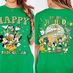 Puede incluir: Camiseta verde con personajes de Disney celebrando el Día de San Patricio. El frente muestra "HAPPY ST. PATRICK'S DAY" con Mickey y amigos. La parte trasera muestra "EPCOT WORLD TOUR 1982" con Spaceship Earth.