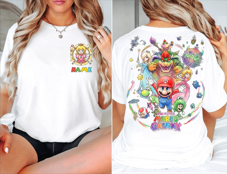Pu&ograve; includere: T-shirt bianco con una grafica colorata di Princess Peach e la scritta "NAME" sul davanti. Il retro della maglietta mostra una vivace illustrazione dei personaggi del gioco "The Super Mario Galaxy".