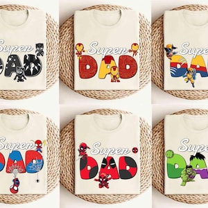 Può includere: Sei magliette color crema con la scritta "Super Dad" in vari design a tema supereroi. Ogni maglietta presenta un personaggio di supereroe diverso, tra cui Black Panther, Iron Man, Wolverine, Spider-Man, Deadpool e Hulk.