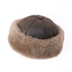 May include: A brown leather hat with a fur trim. The hat has a round shape and a slightly pointed top.