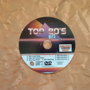 May include: A DVD disc labeled "Top 80's Hits Music Video Mix" with a black and red design. The disc includes 80's Hard Rock, 80's-90's Hard Rock, 80's Pop Rock, and 80's Rad Pop music videos.