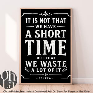 Może przedstawiać: Oprawiony czarno-biały wydruk z cytatem "IT IS NOT THAT WE HAVE A SHORT TIME BUT THAT WE WASTE A LOT OF IT - SENECA-". Wydruk ma drewnianą ramę i elementy dekoracyjne.