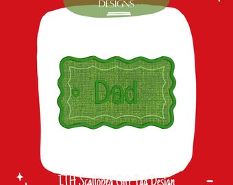 Peut inclure: Une étiquette cadeau brodée verte avec le mot "Dad" dans une police décorative. L'étiquette a un bord festonné et est placée sur un fond blanc avec une bordure rouge. Le texte "PLAYFUL EMBROIDERY DESIGNS" est en haut.