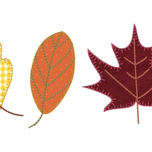 May include: Three felt leaves in different colors and shapes. A yellow and white gingham oak leaf, an orange leaf with a brown stem, and a burgundy maple leaf.
