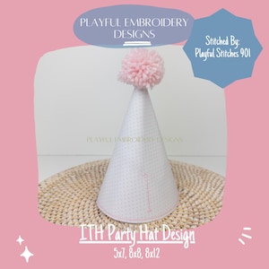 Op de afbeelding: Een witte feestmuts met roze stippen en een roze pompon bovenop. De muts is geborduurd met een roze lijn. De muts ligt op een geweven mat. De tekst "ITH Party Hat Design 5x7, 8x8, 8x12" staat onder de muts.