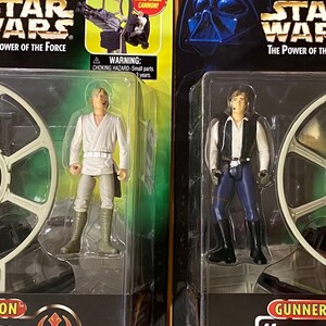 May include: Two Star Wars action figure sets featuring the Millennium Falcon Gunner Station. The set on the left includes Luke Skywalker and the set on the right includes Han Solo. Both sets feature a gray plastic model of the Gunner Station and a figure of the character.