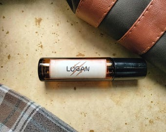 May include: A brown glass roller bottle with a white label that says "LOGAN" with a red claw mark design.