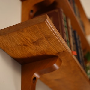 Detail shot of bottom shelf corner showing the grain of the wood.