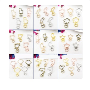 May include: Assortment of 18 metal keychains with different animal and shape designs. The keychains are available in gold, silver, and rose gold finishes.