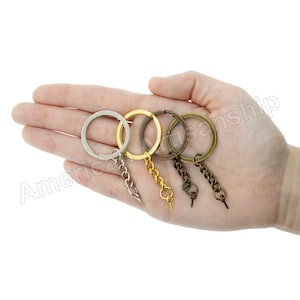 May include: Four key rings with attached chains. The key rings are silver, gold, and two shades of bronze. The chains are silver, gold, and bronze.