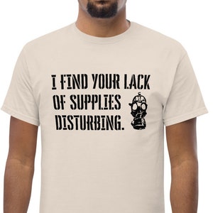 May include: A beige t-shirt with black text that reads "I find your lack of supplies disturbing." and a black and white gas mask graphic.