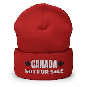 May include: Red knitted beanie with a white embroidered design that says "CANADA NOT FOR SALE" with a black maple leaf on either side of the text.
