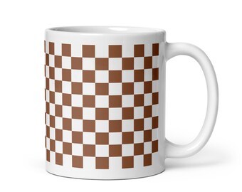 May include: White ceramic mug with a brown and white checkered pattern.