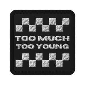 May include: Black and white checkered patch with the text "Too Much Too Young" in white.
