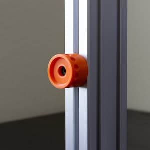 May include: Orange plastic knob with a hole in the center, attached to a silver metal frame.