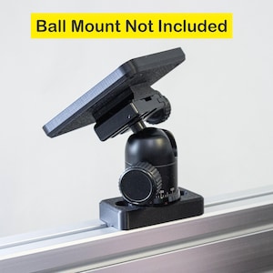 May include: Black camera mount with a ball joint and a square base. The mount is attached to a silver track. "Ball Mount Not Included" is written in yellow text at the top of the image.