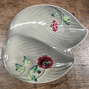May include: A grey ceramic serving dish with two sections, decorated with red poppy flowers and green leaves.